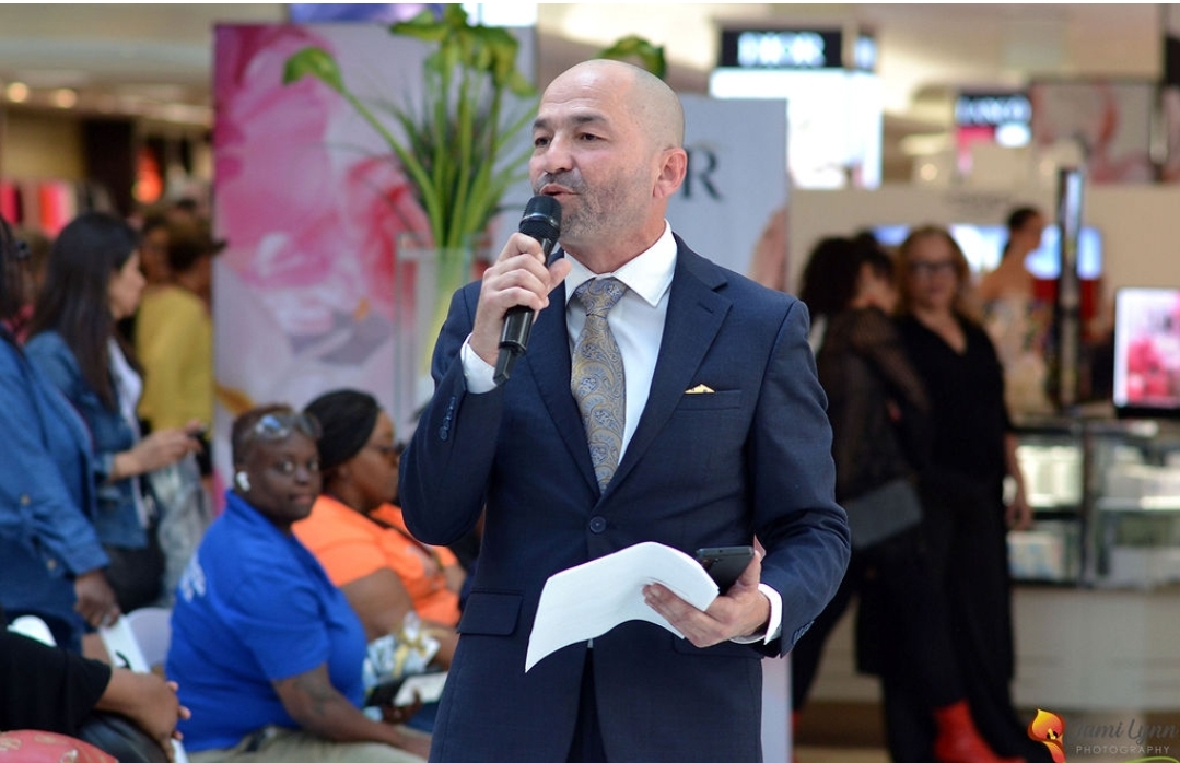 Chris Maloof speaking on a microphone at an event